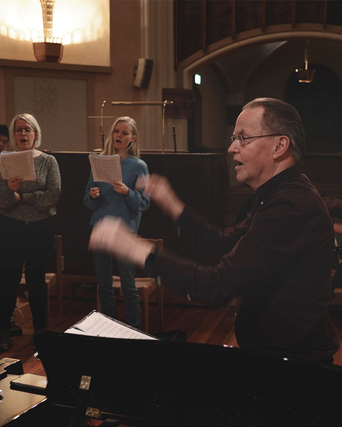 Bengt Ollén dirigerar körsångare under repetition