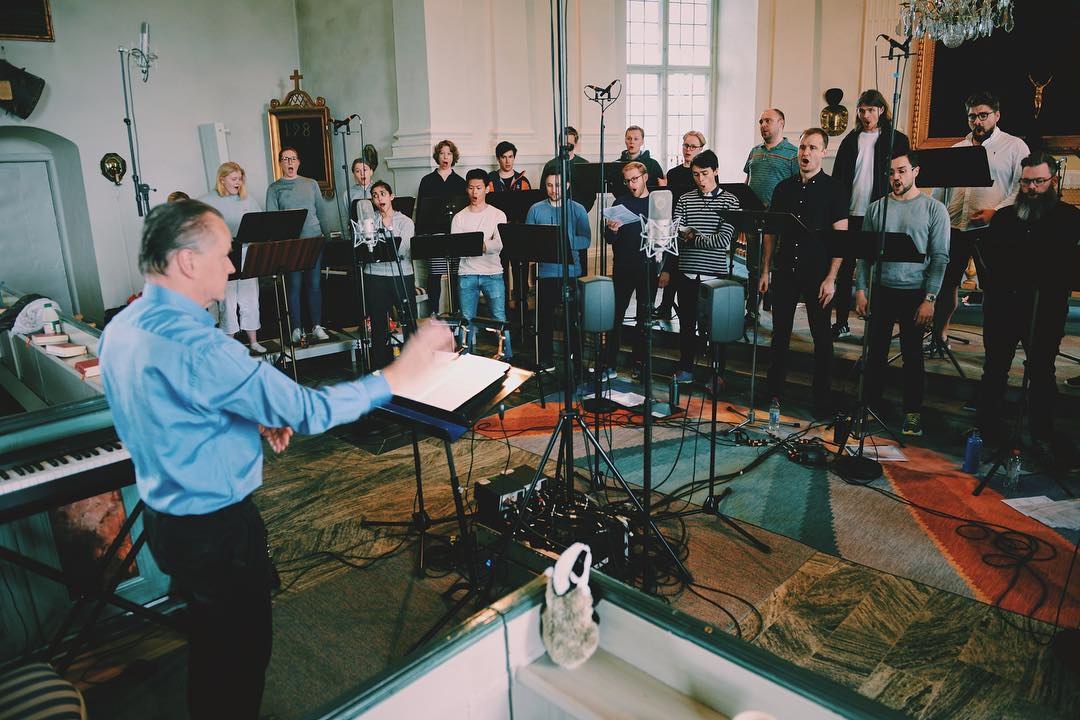 Bengt Ollén leder kören vid mikrofonerna i Hölö kyrka