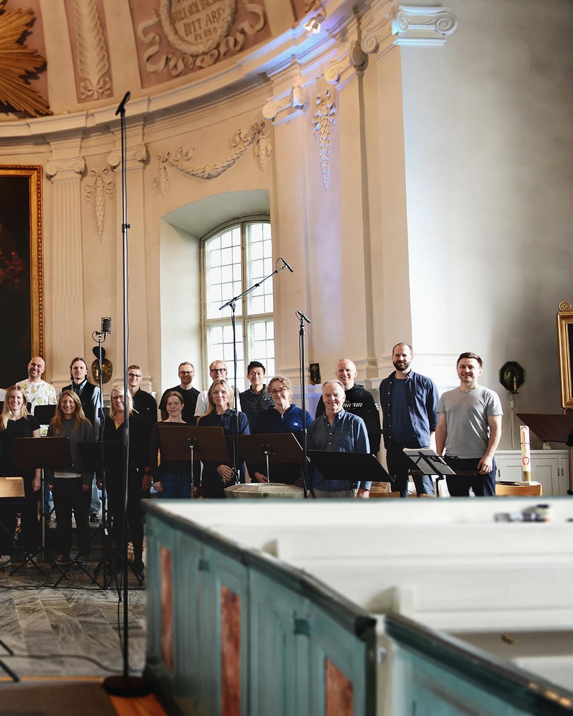 Bengt Ollén och körsångare bland mikrofoner och notställ i Hölö kyrka